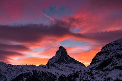 Scenic view of snowcapped mountains against sky during sunset