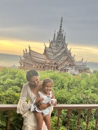 Portrait of young woman standing against sky during sunset