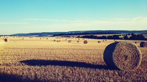 Hay bales on field against sky