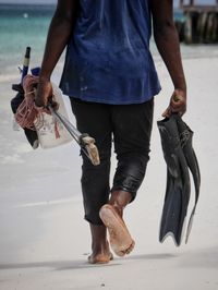 Low section of fisherman walking