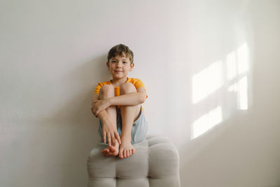 Cute boy sitting barefoot in a home. beautiful light.