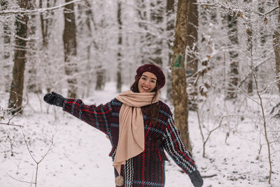 Beautiful young woman enjoying a wonderful winter day in the forest. 