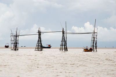 Sailboats on beach against sky