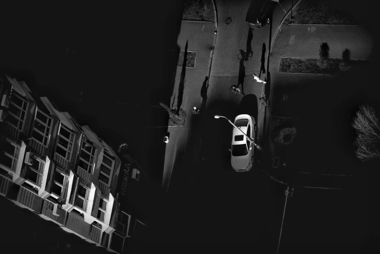 CARS ON STREET AMIDST BUILDINGS AT NIGHT