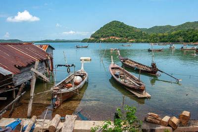 Boats moored in lake against sky