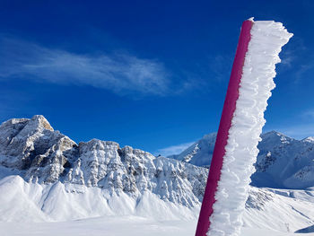 Snow covered mountain against blue sky