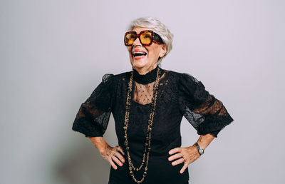 Portrait of young woman wearing sunglasses against white background