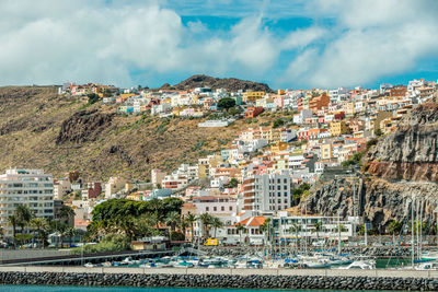 Aerial view of town by sea against sky