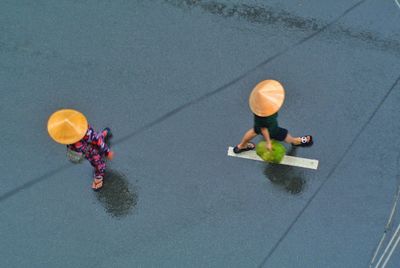 High angle view of people walking on wet footpath during rainy season