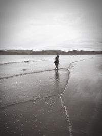 Silhouette man in sea against sky