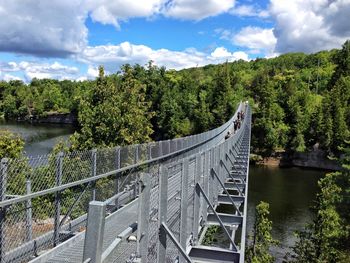 Bridge over river against cloudy sky
