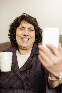 Portrait of smiling woman using mobile phone