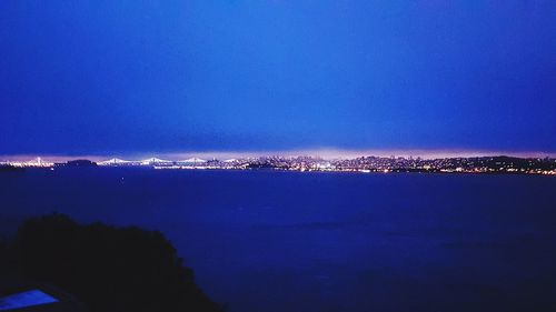 Illuminated city against sky during sunset