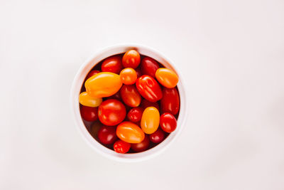 High angle view of tomatoes in bowl against white background