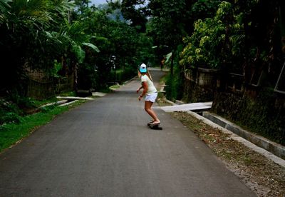 Full length of man skateboarding on road