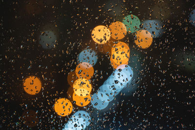 Blurred bokeh city lights, raindrops on window glass