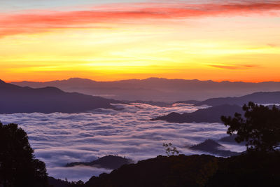 Scenic view of silhouette mountains against orange sky