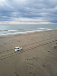 Van driving a long infinite sandy road