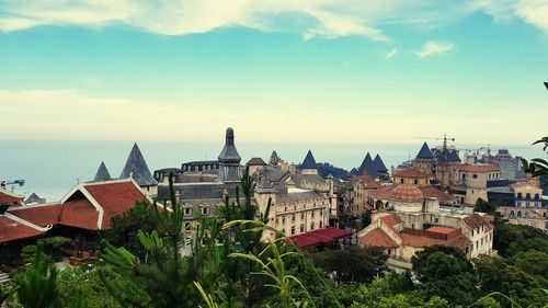 Houses and buildings in town against sky