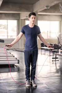 Handsome man training with his skipping rope best cardio workout at fitness gym.