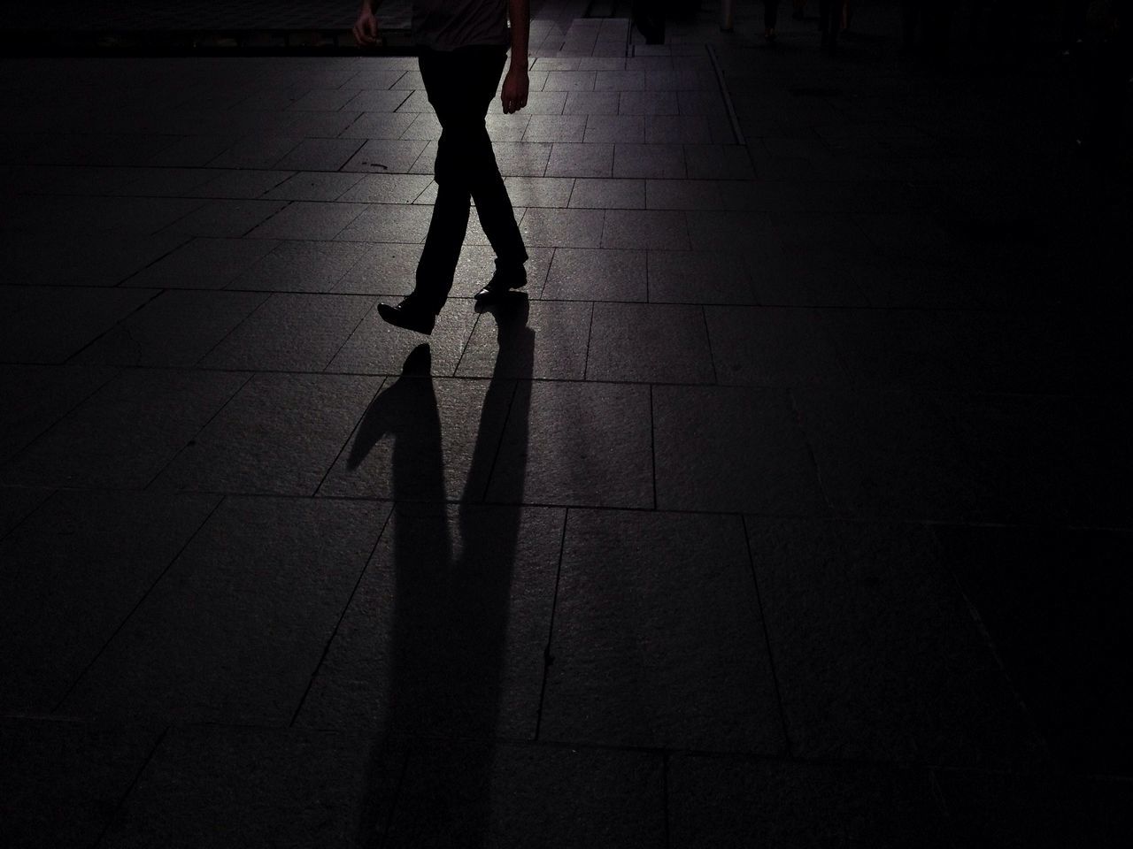 low section, lifestyles, walking, person, shadow, standing, leisure activity, men, street, full length, silhouette, sunlight, unrecognizable person, on the move, day, outdoors