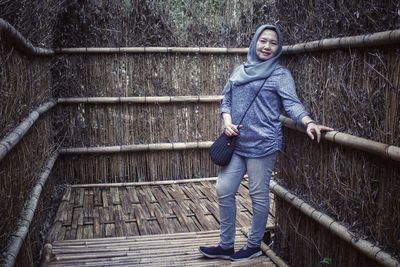 Portrait of smiling woman standing on staircase