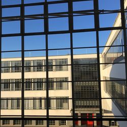 Buildings against sky seen through glass window