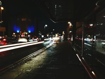 Illuminated railroad tracks in city at night