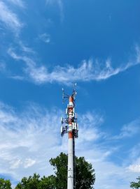 Low angle view of communications tower and building against sky