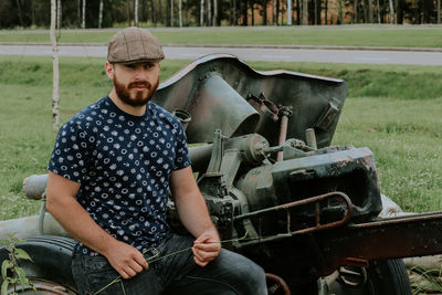 Portrait of young man sitting on field