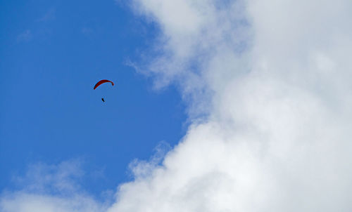 Low angle view of person paragliding against sky