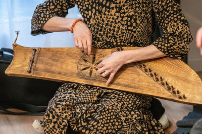 Midsection of woman sitting on sofa at home