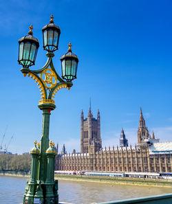 Street light by building against sky