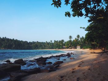 Scenic view of beach against clear blue sky