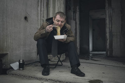 Bankrupt businessman forced to eat cheap food in an abandoned building