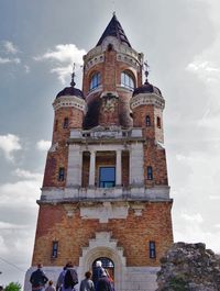 Low angle view of bell tower against cloudy sky