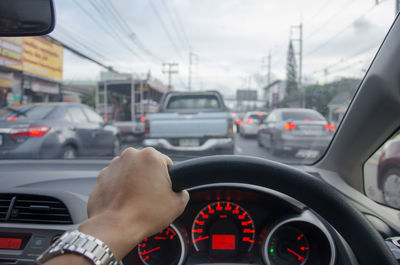 Close-up of hand driving car