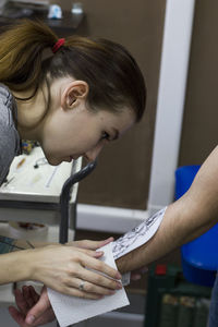 Female tattoo artist tattooing in studio