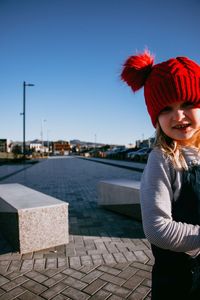 Portrait of smiling woman standing against clear sky