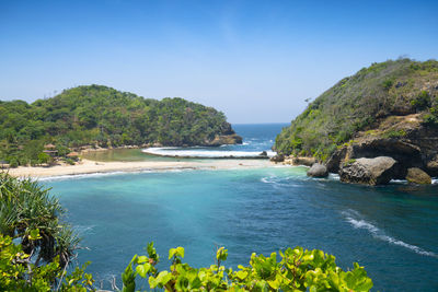 Scenic view of bay against clear blue sky