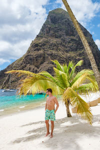 Rear view of woman standing at beach