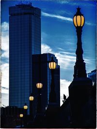 Low angle view of skyscrapers against cloudy sky