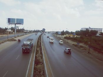 Cars on road in city against sky