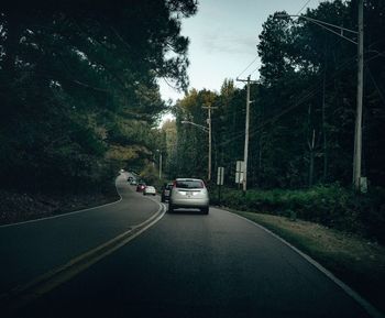 Cars on road in city against sky