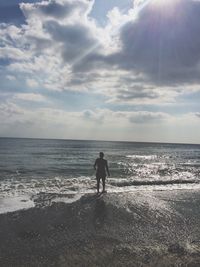 Rear view of silhouette man on beach against sky