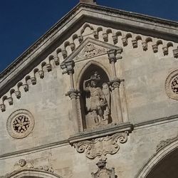 Low angle view of cross against building