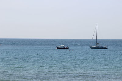 Sailboat sailing on sea against clear sky