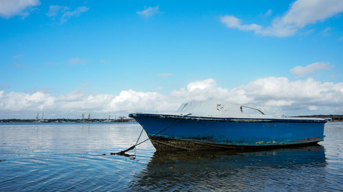 Fishing boat in sea against sky