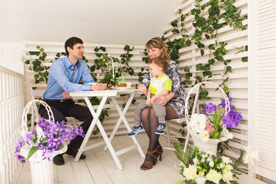 People sitting on table by potted plant