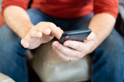 Midsection of man using mobile phone